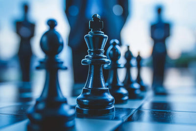 Close-up of a black king chess piece on a chessboard with blurred chess pieces in the background, suggesting strategy and quick thinking