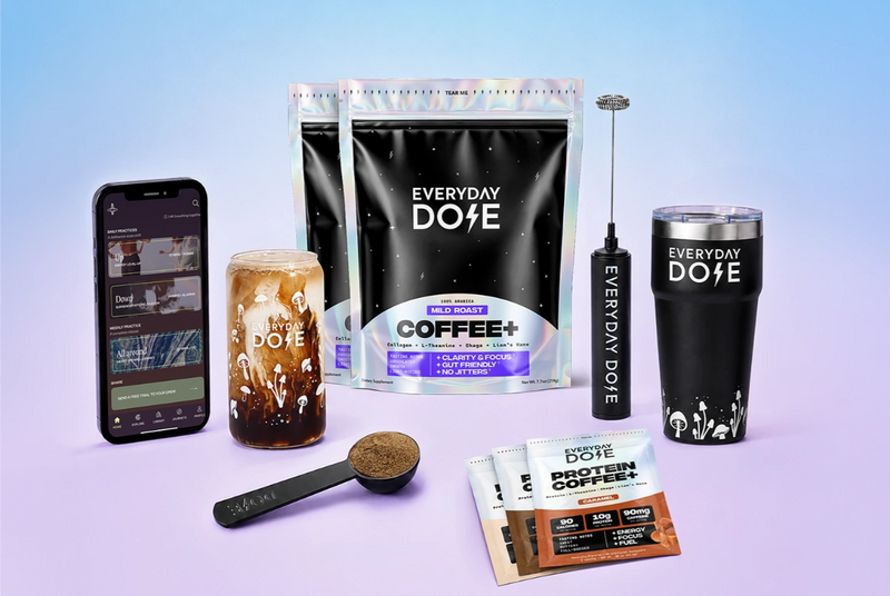 Coffee display with two bags a jar a black tumbler a phone a scoop a stirrer and individual coffee sachets on a pastel background