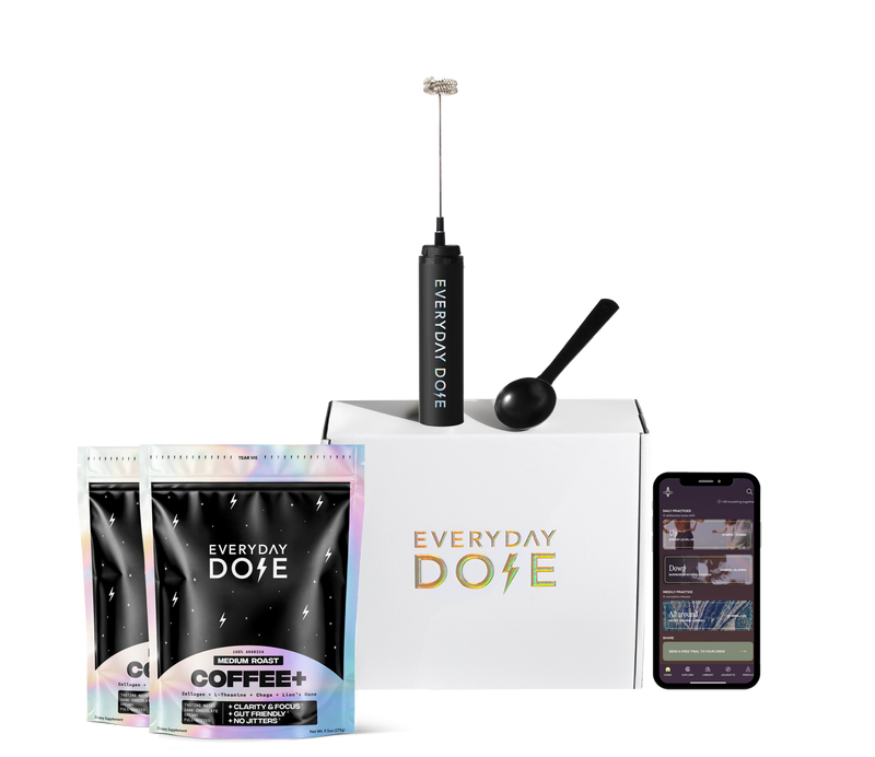 Front view of Everyday Dose mushroom coffee bundle with two pouches, branded box, frother, scoop, and phone on white background