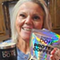Reviewer smiling and holding an Everyday Dose Mushroom Coffee packet