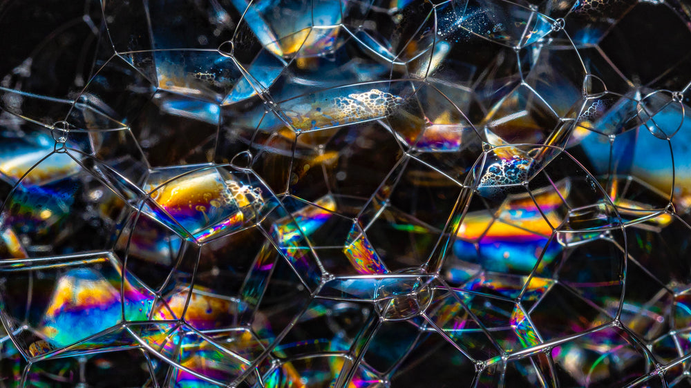 Close-up of iridescent soap-bubble film in blue, gold, and purple hues